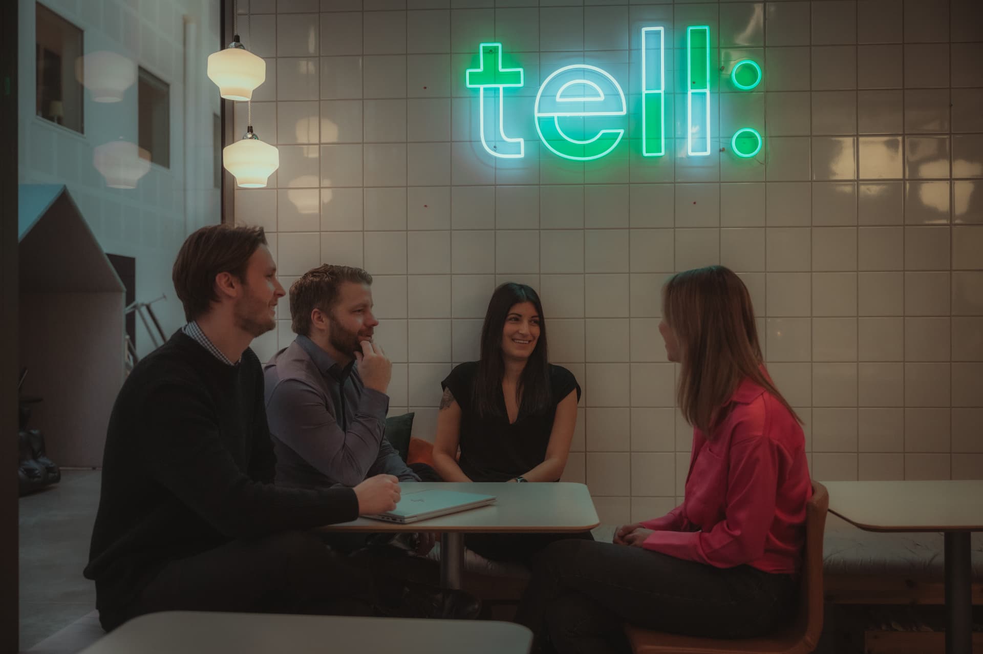 Medarbetare på Tell i samtal under neonskylten
